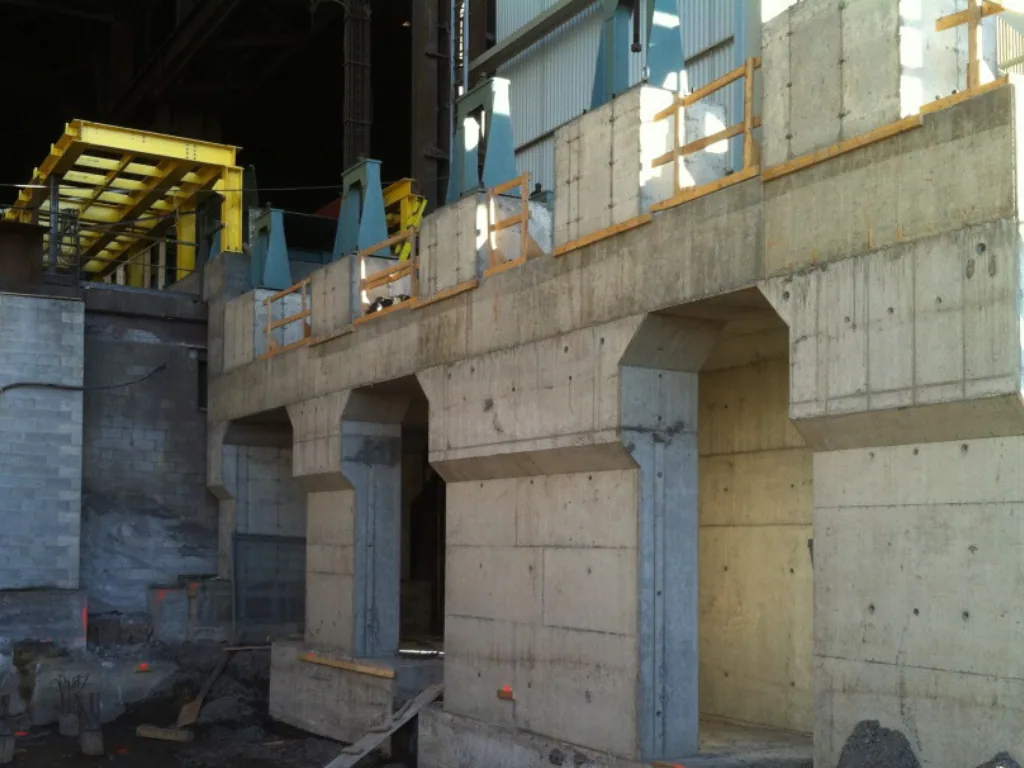 Fondations et murs de béton neufs avec composantes d’acier en attente d’installation.
