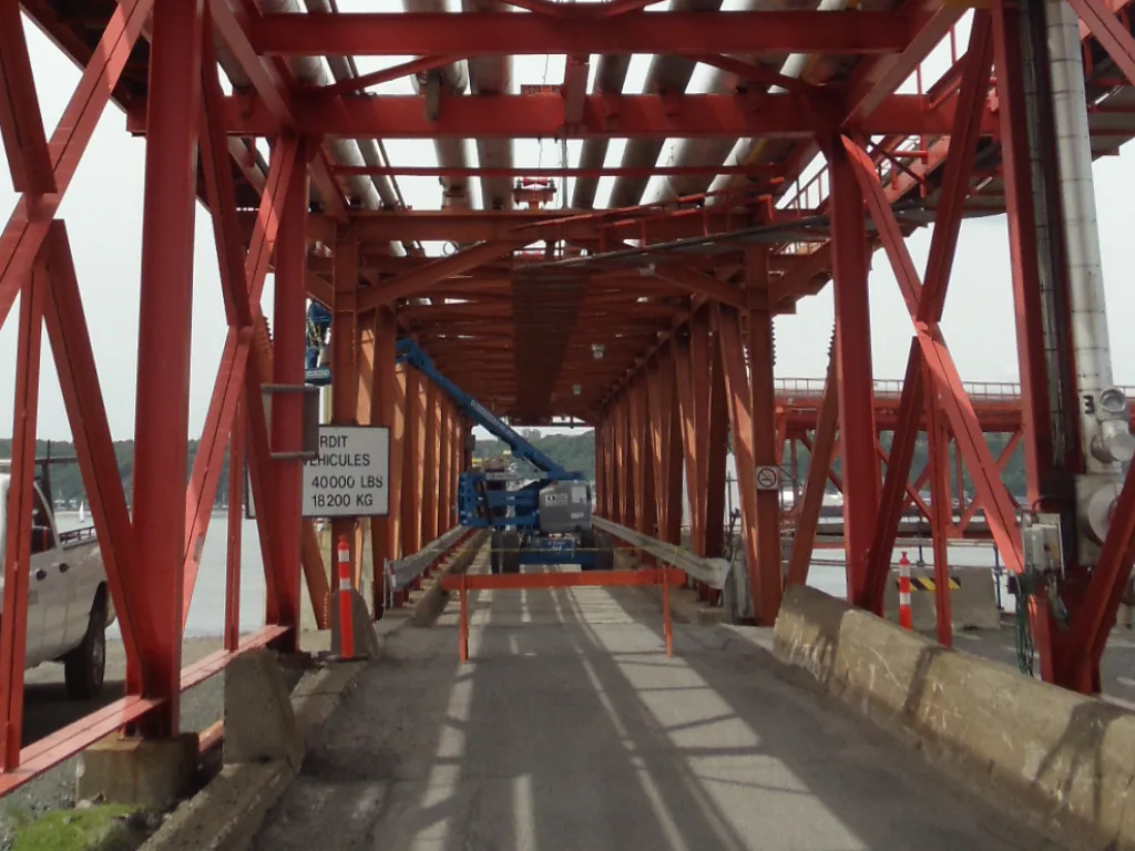 Structure d’acier rouge abritant une passerelle et une conduite de grand diamètre sur le site du projet Valero.