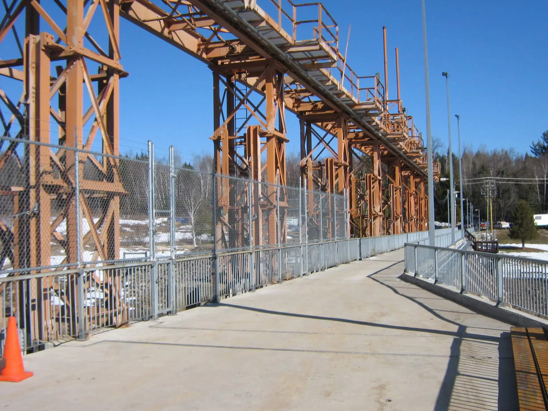 Passerelle ou support de tuyauterie industriel en acier terminé, comprenant escaliers, garde-corps et plateformes surélevées.